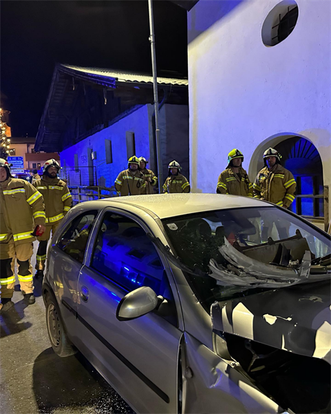 Eine Gruppe von Feuerwehrleuten steht neben einem Auto, das in einen Unfall verwickelt war